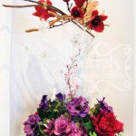 Artificial red mangolia, pink eremurus, pink cherry blossoms, fuchsia peonies, purple hydrangea, and purple anemones centrepiece with suspending butterflies (overview)