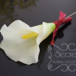 Artificial (soft-touch) white calla lily boutonniere, with wine red satin wrap and double pearl pins