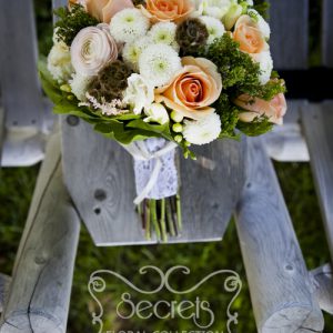 Fresh cream garden roses, peach roses, pink ranunculus, white freesia, scabiosa pods, green trachelium, white button mums, and pink astilbe bridal bouquet, with burlap and lace vintage wrap (front-view) - Toronto Wedding Flowers by Secrets Floral Collection