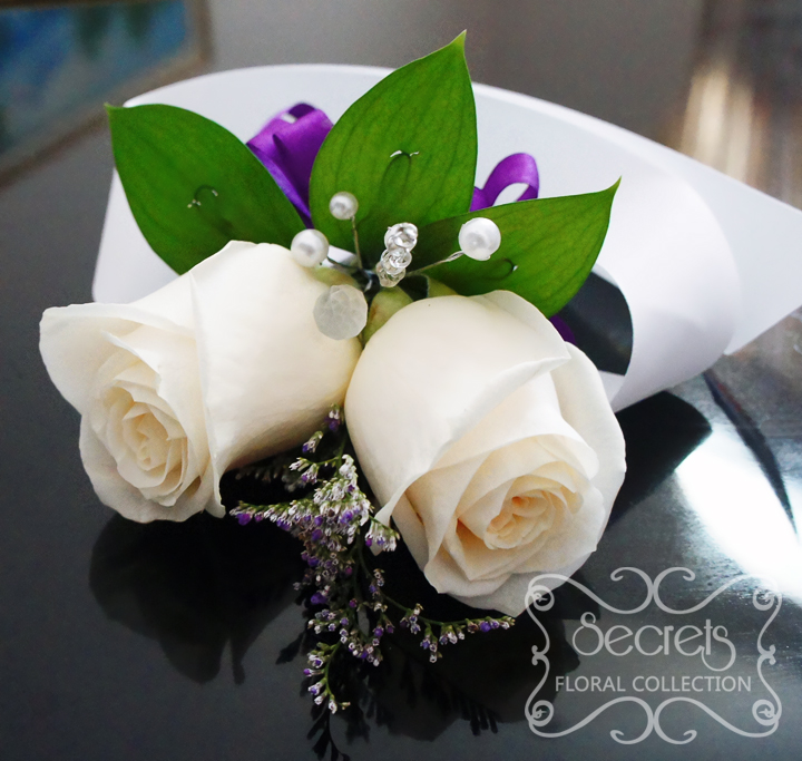 Fresh double-bloom cream roses and purple limonium wristlet corsage, with purple bow and jewel embellishments (top-view) - Toronto Wedding Flowers Created by Secrets Floral Collection