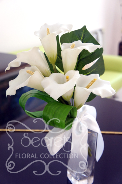 Artificial white calla lilies bridesmaid bouquet, with monstera and aspidistra leafs and tied in white satin bow - Toronto Wedding Flowers Created by Secrets Floral Collection