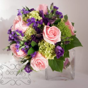 A bridal bouquet with lots of textures. Created with fresh light pink roses, purple lisianthus, baby green hydrangea, green trachelium, and purple statice flower (top view) - Toronto Wedding Flowers by Secrets Floral Collection