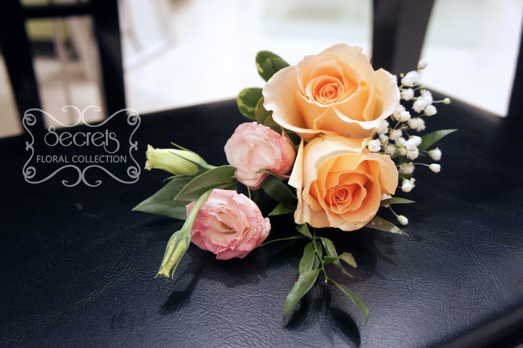 Fresh double-bloom peach roses, pink bi-colour lisisanthus, and baby's breath boutonniere, embellished with coral and white stripe-pattern ribbon (top-view) - Toronto Wedding Flowers Created by Secrets Floral Collection