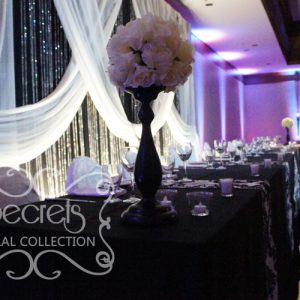 Head Table are Decorated with Ivory Ball on Black Stand Arrangements and Small Bling! Bling Candle Holders