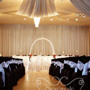 Chairs are Decorated in Black Fitted Polyester Chair Covers, with White Satin Sashes