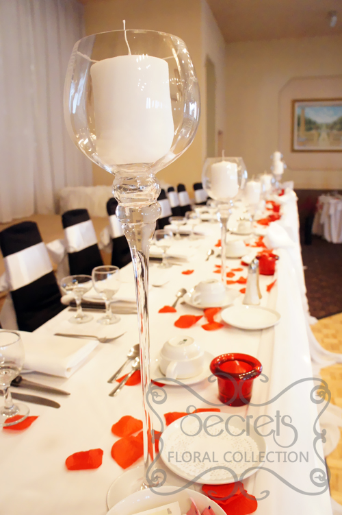 Set-up of Head Table, with Red Petals, Red Candles Holders, and Tall Stemmed Glass Candle Holders