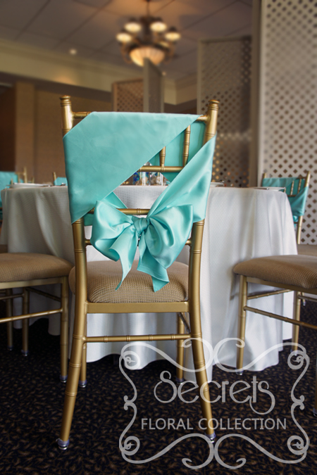 Close-up of chiavari chair, demonstrating how we have tied the Tiffany blue satin sashes in a unique way (diagonally)!