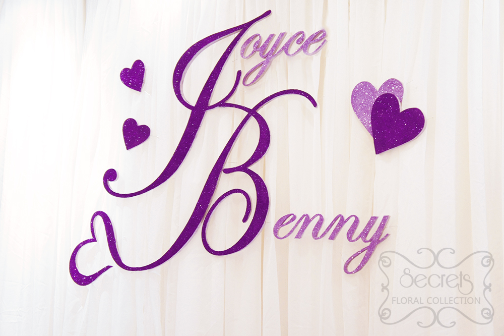 Close-up of purple glittery names. Designed with trailing heart