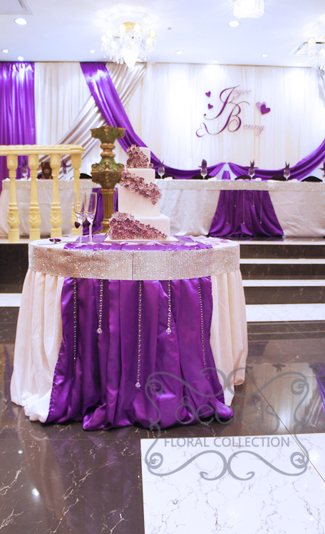 Cake table decorated with white crinkled linen and purple satin stripe. Table is crystallized with the Bling! Bling! edge and suspending crystal strands