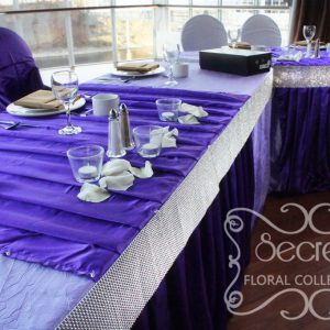 Close up up head table, with pleated royal purple stripes