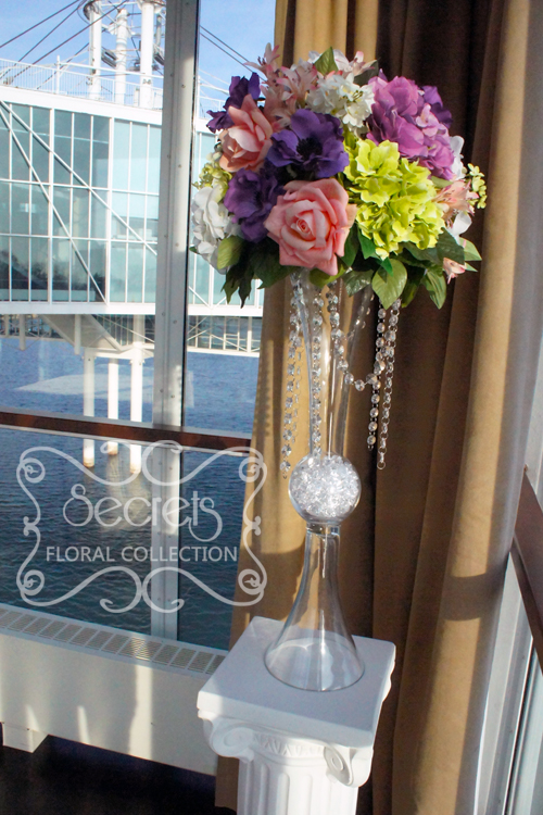 Each arrangement is made with purple anemone, salmon pink roses, (green, lavender, and white) hydrangea, and (white and green) lilac, on reversible vase with crystal strands