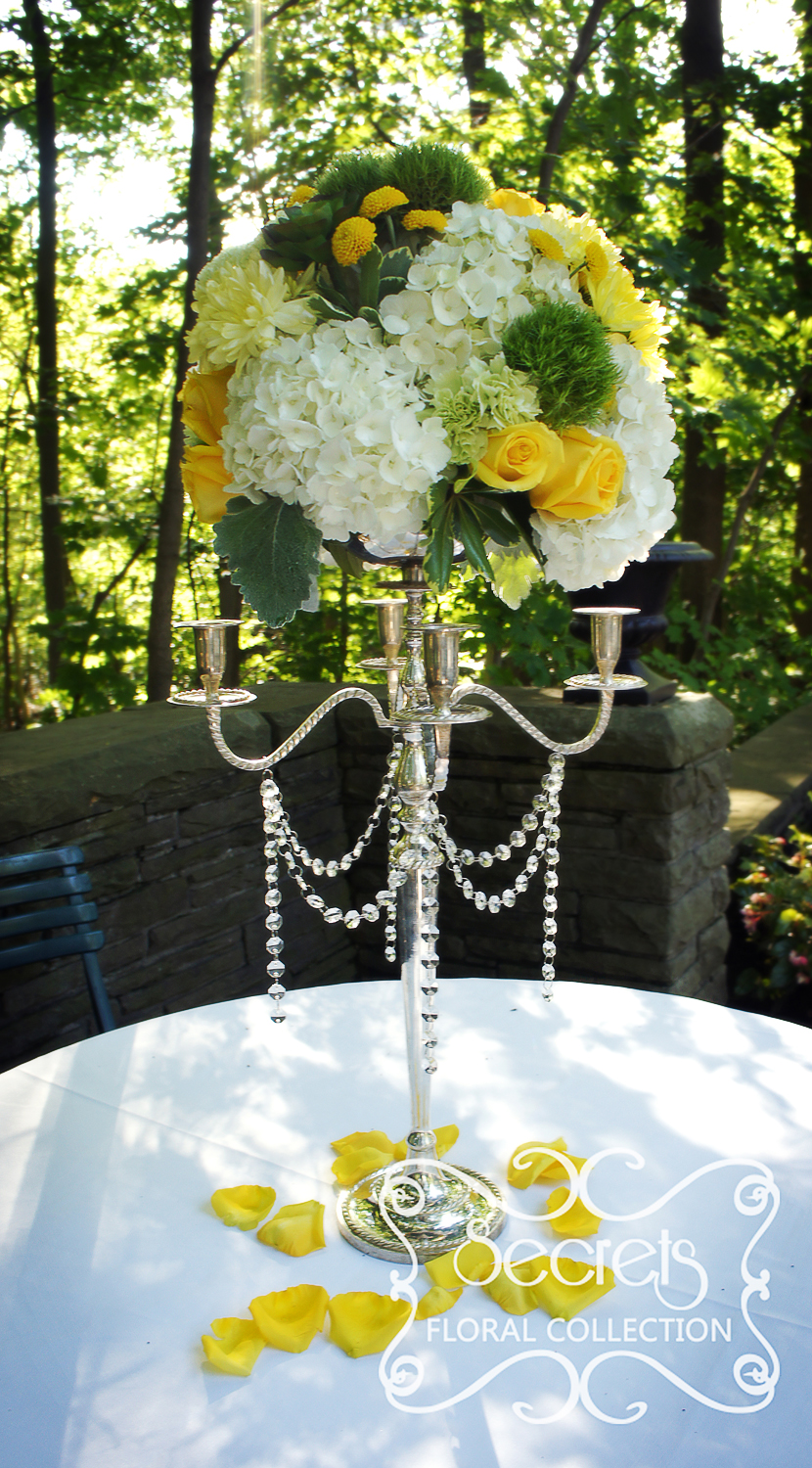 Elevated cream, green, and yellow centrepieces were used in the ceremony as well