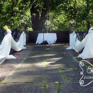 Outdoor ceremony with cream chiffon swags along the 2 sides of aisle