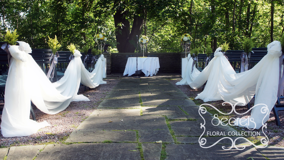 Outdoor ceremony with cream chiffon swags along the 2 sides of aisle