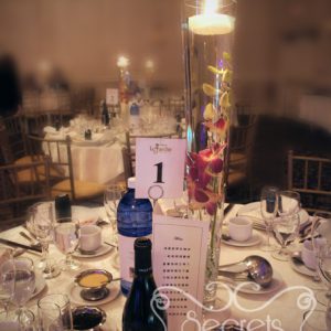 Two-tone fuchsia and peach dendobrium orchid centrepiece, with submerging flower and floating candle - Toronto Wedding Decor Created by Secrets Floral Collection