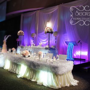 Parts of head table are dressed with ivory tablecloth and white ruffled trims - Toronto Wedding Decor Created by Secrets Floral Collection