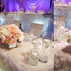 Low-profile head table arrangement with white, cream, and light pink flowers (roses, garden roses, peonies, hydrangea) in a modern mirrored vase - Toronto Wedding Decor Created by Secrets Floral Collection