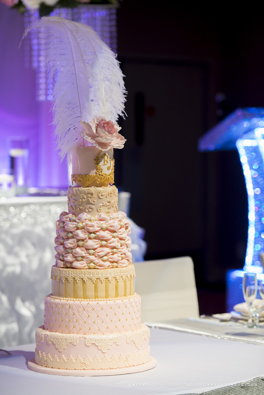 Beautiful and luxurious pink and gold wedding cake, with white ostrich feathers cake topper. Photo by Andes Lo Photography - Toronto Wedding Decor Created by Secrets Floral Collection