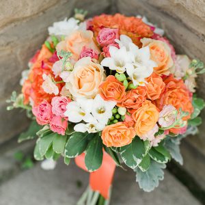 A colourful and vibrant bridal bouquet, with fresh coral garden roses (free-spirit), peach roses, stock flowers, white freesia, and spray roses - Toronto Wedding Flowers by Secrets Floral Collection