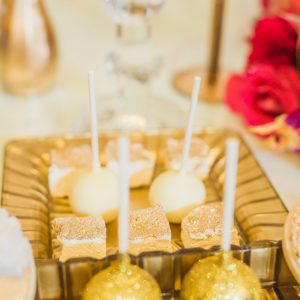 Detail shot of dessert tray at the Victorian Convention centre, Missisauga. Candy pops and dessert squares are accented with gold glitter. Decor by Secrets Floral.