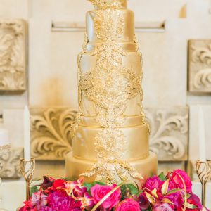 Gorgeous, gold wedding cake at the Victorian Convention centre, Missisauga. Decorated with real flowers at the bottom tier, such as hot pink gerbera daisy, fuscia dendrobium orchids, gold foliage, pink calla lily, hot pink rose. Flower and decor by Secrets Floral.