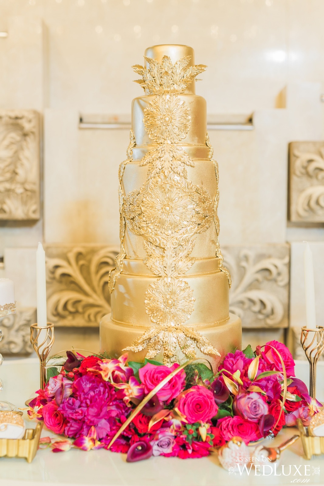 Gorgeous, gold wedding cake at the Victorian Convention centre, Missisauga. Decorated with real flowers at the bottom tier, such as hot pink gerbera daisy, fuscia dendrobium orchids, gold foliage, pink calla lily, hot pink rose. Flower and decor by Secrets Floral.
