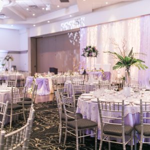 Wedding reception at Fontana Primavera, with tall centrepieces, purple tablecloths, and gold overlay linens. Toronto wedding flowers and decor by Secrets Floral.