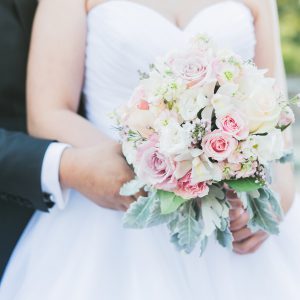 Fresh cream and blush pink bridal bouquet, with roses, lisianthus, cymbidium orchids, stock flowers, and dusty miller. Toronto wedding flowers by Secrets Floral.