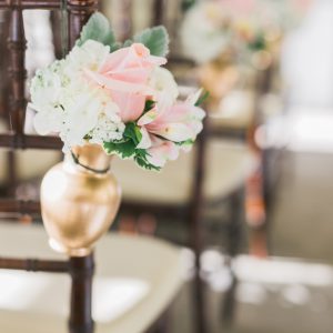 Fresh cream and blush pink wedding ceremony pew markers, with roses, hydrangea, and dusty miller in gold vases. Toronto wedding flowers by Secrets Floral.